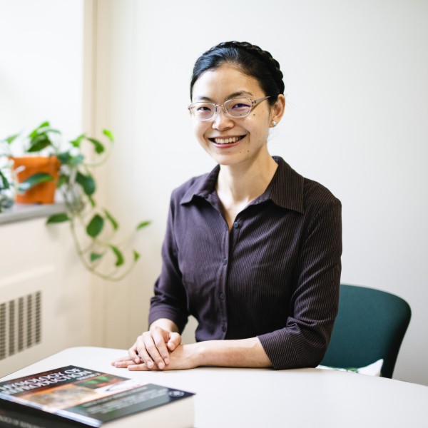 Yi Athena Ren sits at her desk.