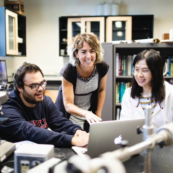 Chelsea Specht works at a desk with two students.