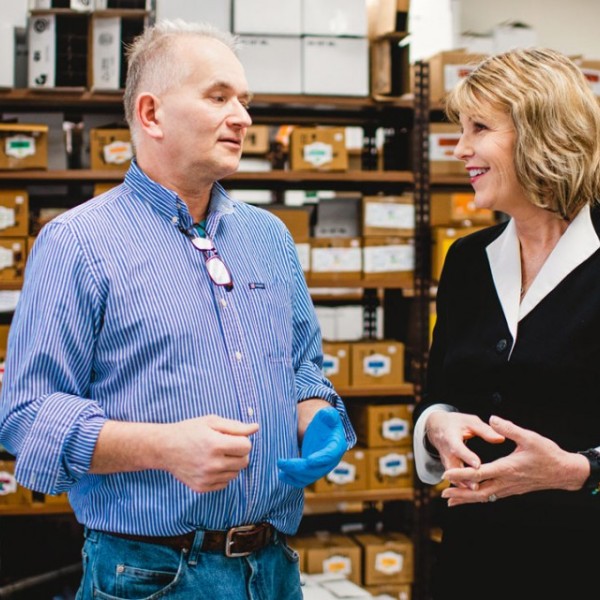 Older man and woman speak to each other in a storage room