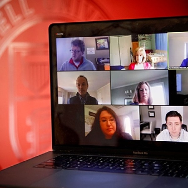 A laptop screens shows 7 people on a Zoom call.