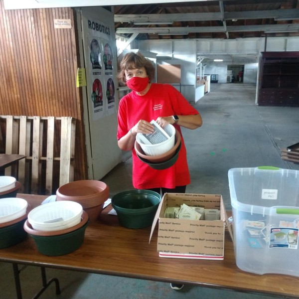 a woman behind a table making a container garden