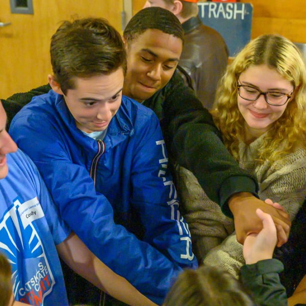 Group of youth in circle with hands together