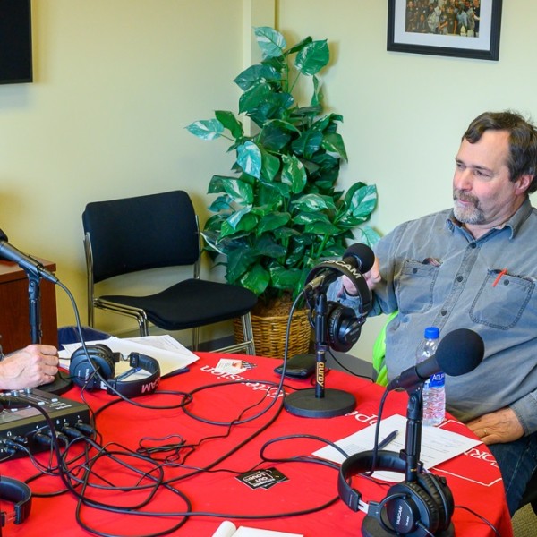 two men talking with audio recording equipment 