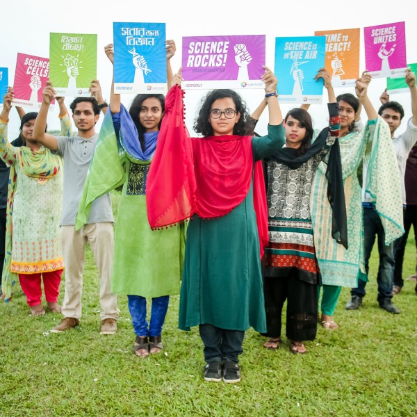People hold signs in support of science