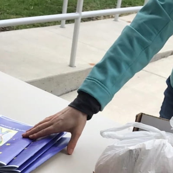 person picking up activity book