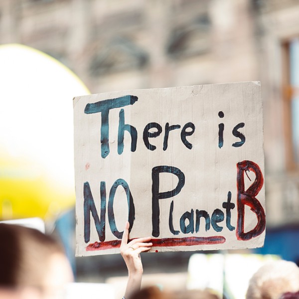 A protester holding a sign that says there is no planet B