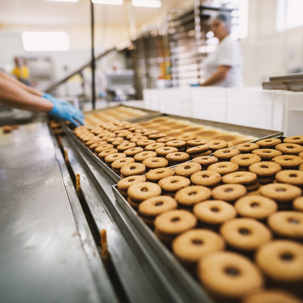 A person working in a donut food production line