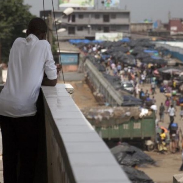 A young man looks out over a bustling street