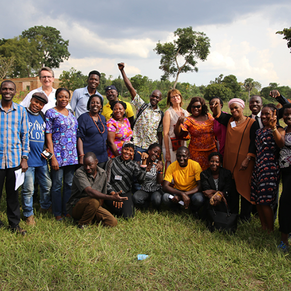 A group poses in a field in Africa