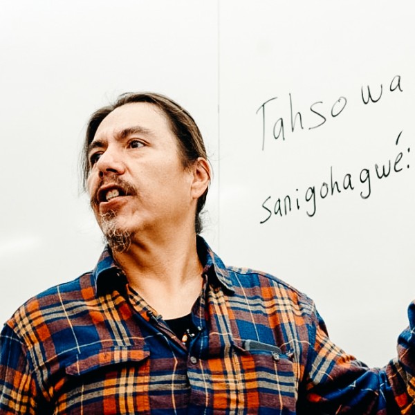 Steve Henhawk stands in front of a white board.