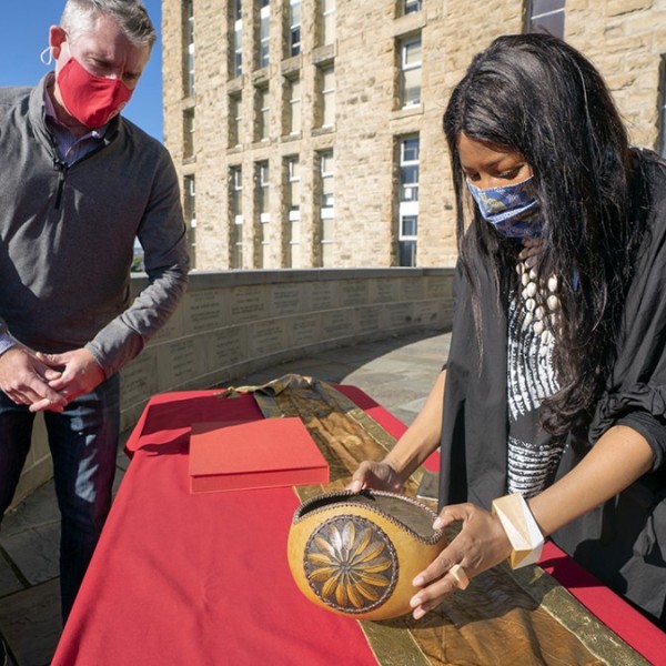 Tamar Evangelestia-Dougherty examines a bowl presented by Mohegan Tribal Historic Preservation Officer James Quinn.