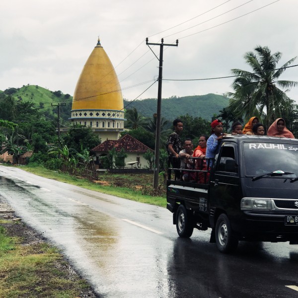 Group rides in the bed of a pick up truck in rural Indonesia