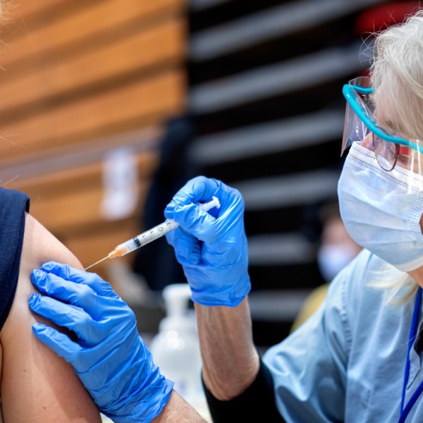 A person giving another person a vaccination indoors