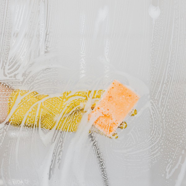 A gloved hand cleans a glass surface