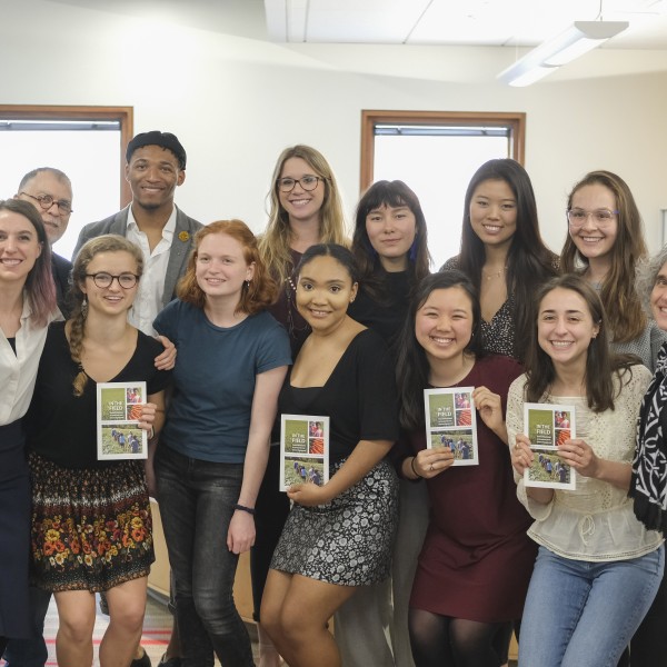 Group of students poses with book