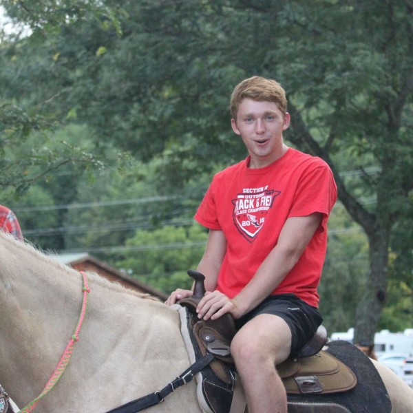 Lucas sitting on a horse outside