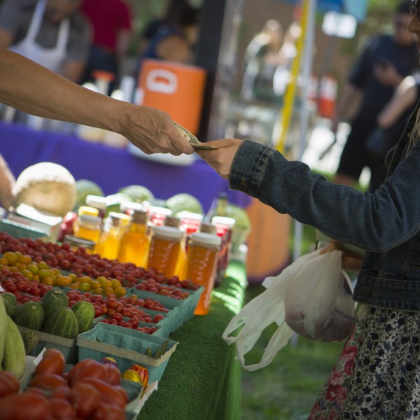 Two people exchanging money at a farmers market