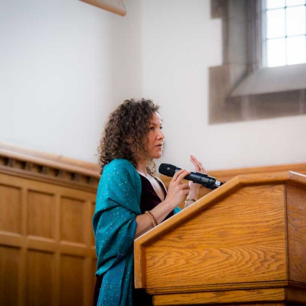 Polly Endreny Holmberg at a lectern speaking into a microphone