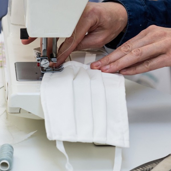 Hands working a sewing machine