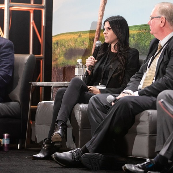 People sitting on chairs on a stage at the Grow NY Summit talking