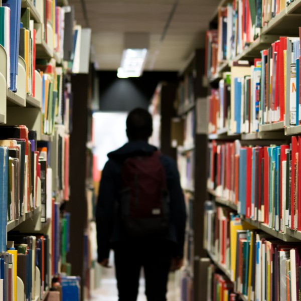 Man with backpack in library