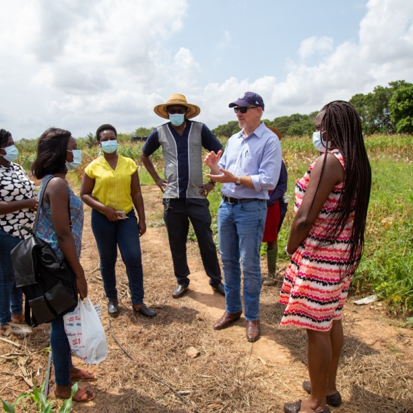 A group speaks together outside in a field 