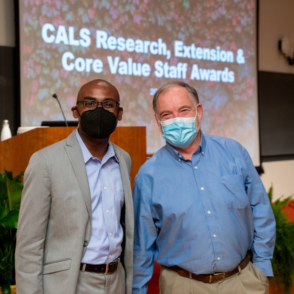 Two men standing at the front of the room in front of the presentation screen
