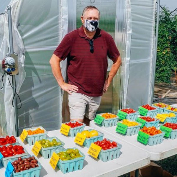 Phillip Griffiths stands outside a greenhouse with his Galaxy Suite of grape tomatoes.