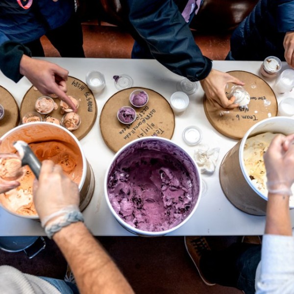 Teaching assistants scoop out the ice cream flavors and hand them to students 