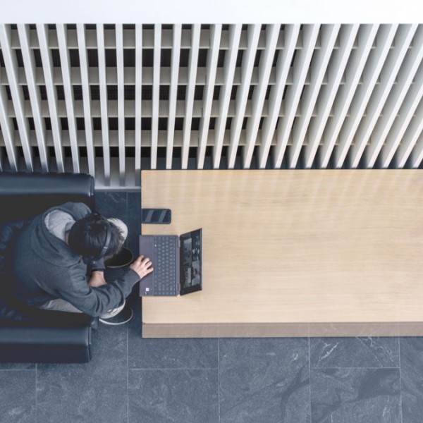 A student sitting in a chair and working on a lap top at a table