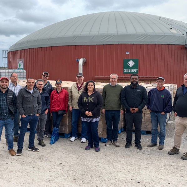 Group standing in front of an anaerobic digester at a Western NY dairy farm