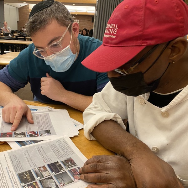 Two men study papers
