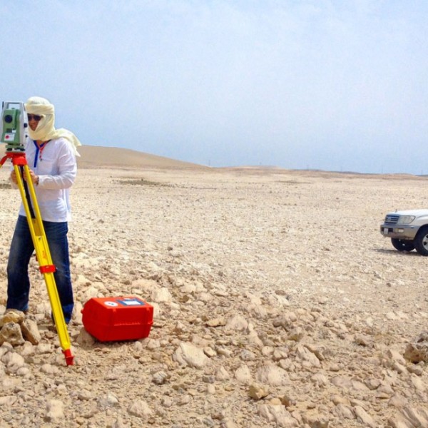 A grad student surveying sand dunes in a desert 