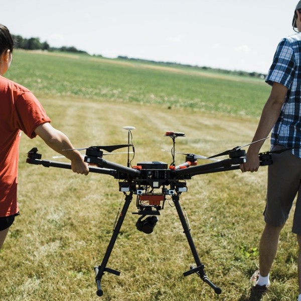 Two people holding a drone.
