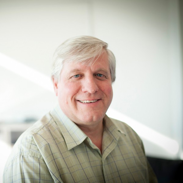 A man smiling in a sunny lab