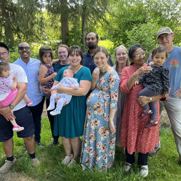 Group poses for photo in front of tree