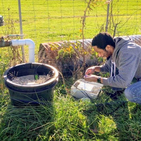 PhD student installs moisture sensors in a field.