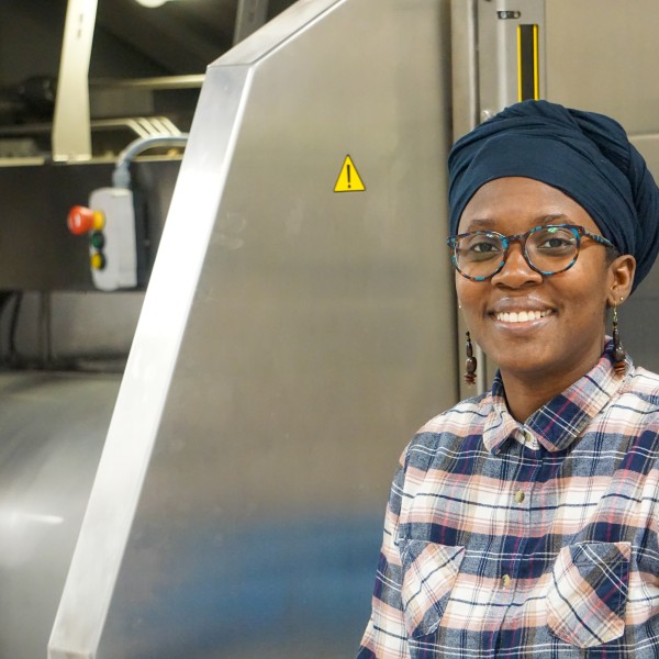 A headshot of Ann Vegdahl sitting beside an HPP machine. 