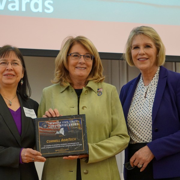 Olga Padilla-Zakour, Pam Helming and Cathy Young standing in a row. Helming is holding a commemorative plaque. 