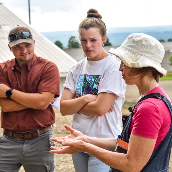 three people talking on a farm