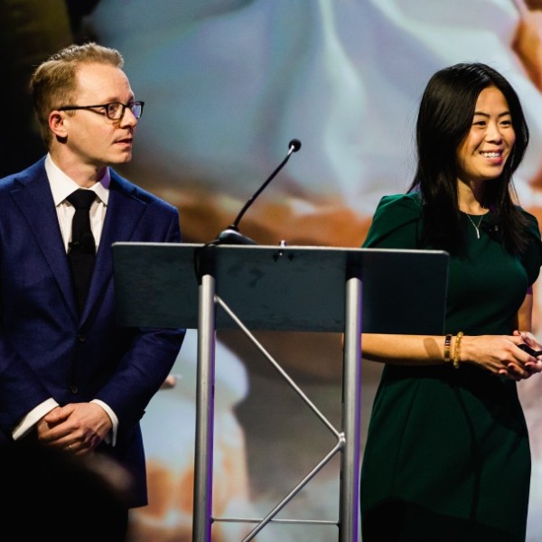 Two people standing on stage giving a presentation.