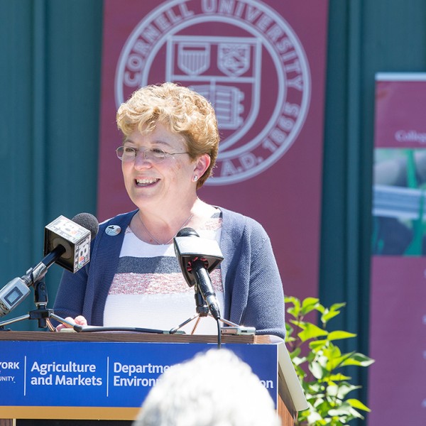 Dean Kathryn Boor speaks at a podium with Cornell banners in the background