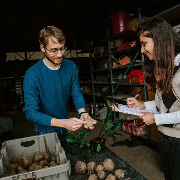 Eric Branch examines a beet with fellow grad student, Pratibha Sharma