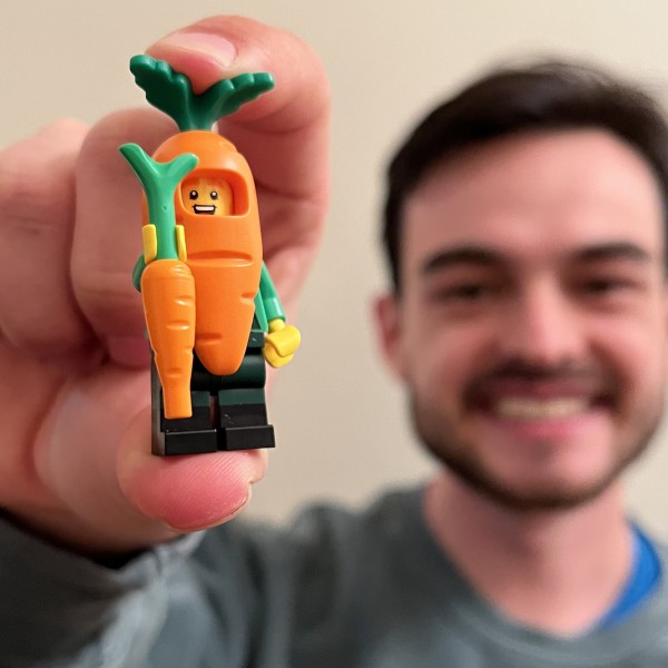 A man holds a carrot LEGO figurine