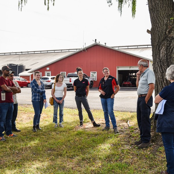 People standing outside next to a barn