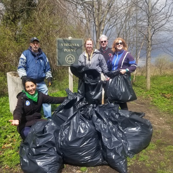 A group of people stand next to garbage bags filled with marine debris on Long Island Sound