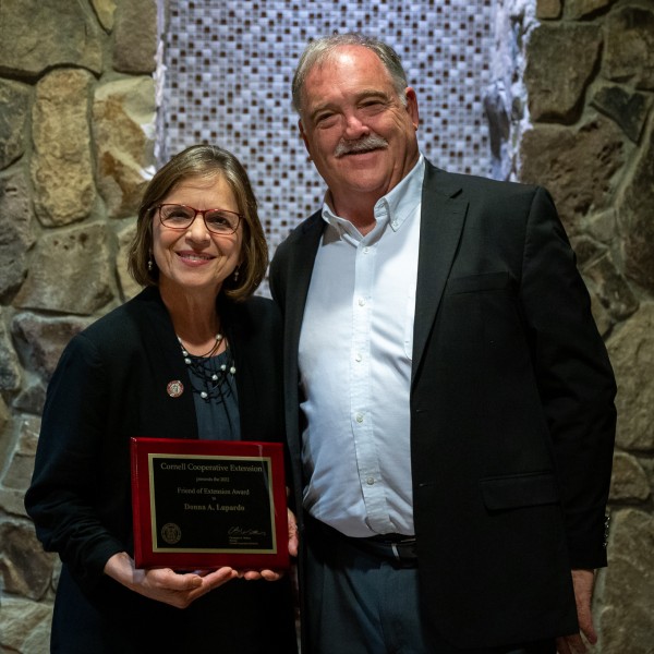 Assemblywoman Donna Lupardo holds an award plaque and stands next to CCE Director Chris Watkins