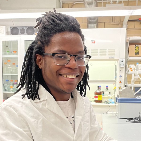 Xavier Panky smiling wearing a lab coat in a lab