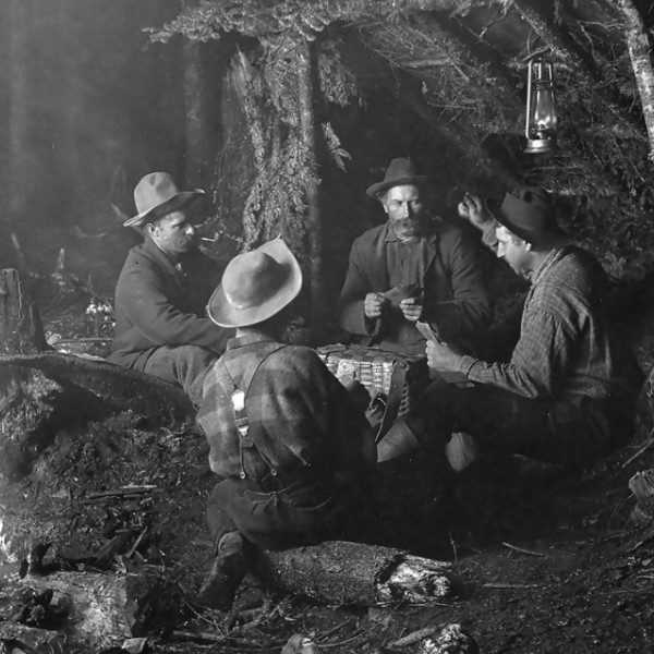 Men sitting around a campfire playing a game