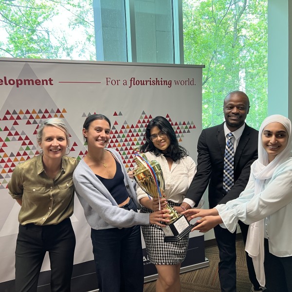 Students and professor hold a trophy